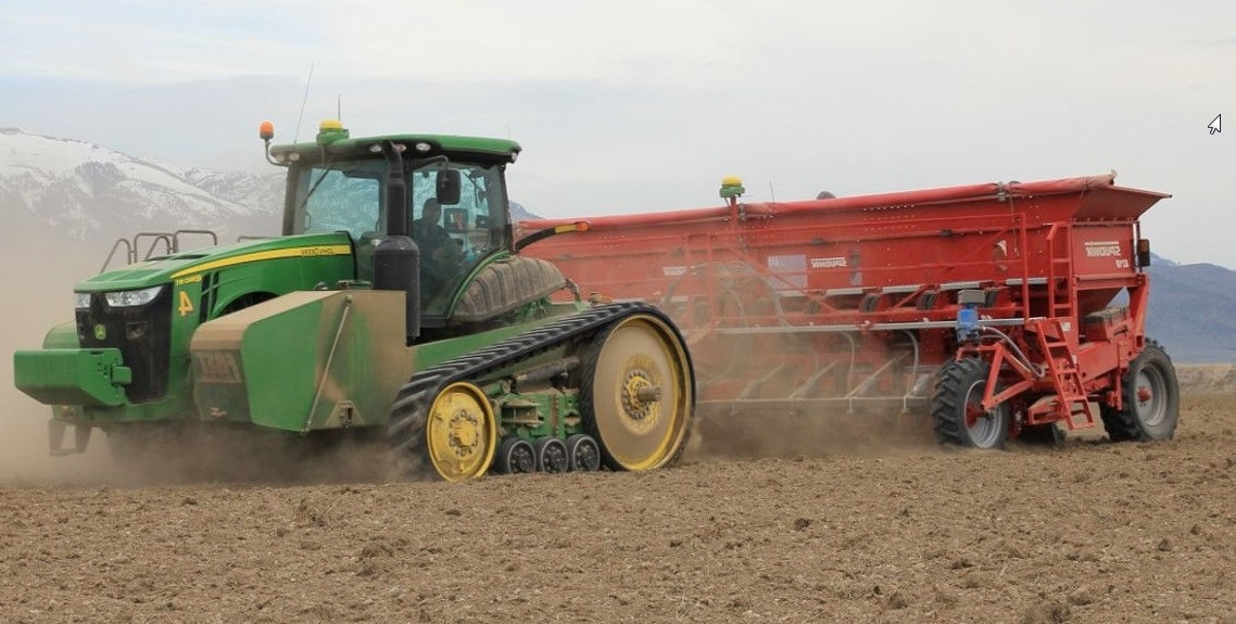 Tracteur agricole et machine planteuse dans un champ