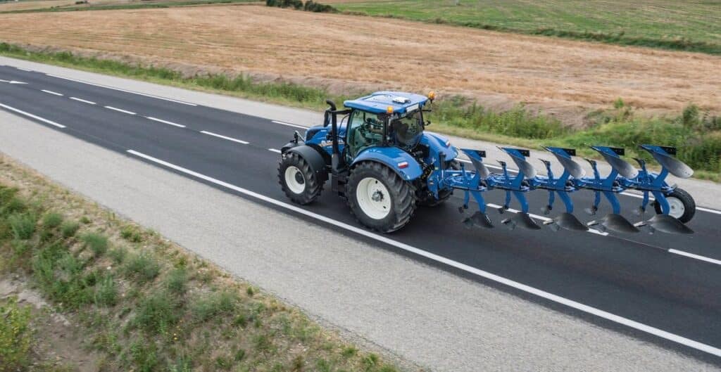 Tracteur agricole roulant sur une route rurale