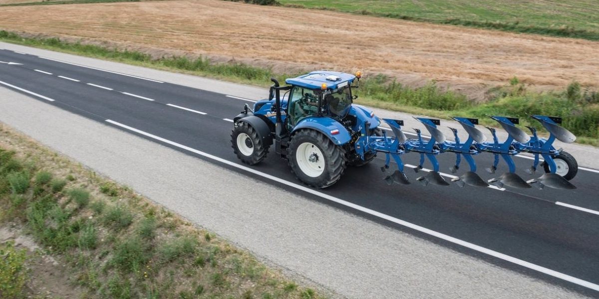 Tracteur agricole roulant sur une route rurale